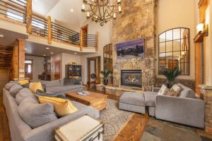 a living room with couches and a stone fireplace at Expansive elegance at base of Peak 8, 6 en-suites, 9 fireplaces, game tables, hot tub! in Breckenridge