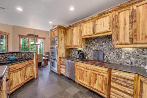 a large kitchen with wooden cabinets and counters at Expansive elegance at base of Peak 8, 6 en-suites, 9 fireplaces, game tables, hot tub! in Breckenridge