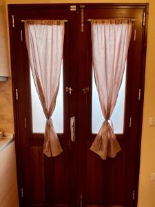a pair of doors with curtains in a room at Kleanthi and Kostas Studios in Symi