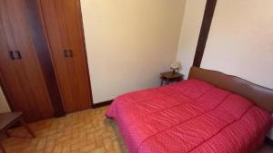 a bedroom with a bed with a red blanket at Au bénédit ii in Vielle-Saint-Girons