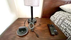 a lamp on a wooden table next to a bed at San Angel Villas in San Antonio