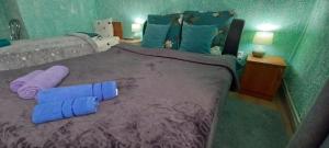 a bedroom with a bed with purple sheets and blue towels at Апартаменти в гостьовому будинку in Mukacheve
