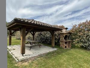 ein Holzpavillon mit Picknicktisch und gemauertem Ofen in der Unterkunft Jouanon in Bias