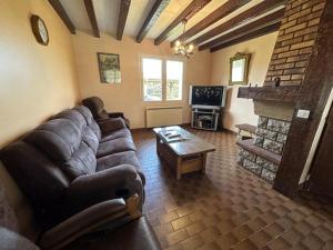ein Wohnzimmer mit Sofa und Kamin in der Unterkunft Jouanon in Bias