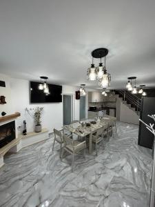 uma sala de jantar com uma mesa e cadeiras num piso de mármore em Casa Berbec2 em Dealul Viei
