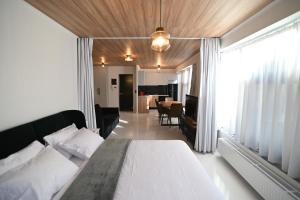 a bedroom with a bed and a living room at Modern Downtown apartment + FREE parking in Larisa