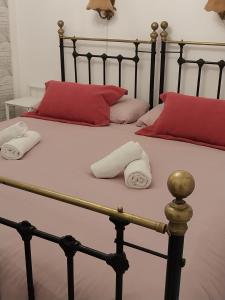 2 Handtücher auf einem Bett mit roten Kissen in der Unterkunft Casa Trebol Parquing Gratis in Estepona