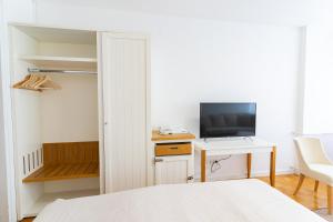 a bedroom with a bed and a desk with a television at Artearia Hotel in Bjelovar