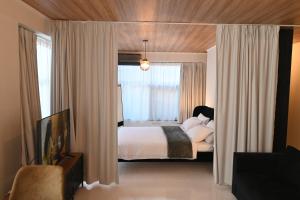 - une chambre avec un lit et une grande fenêtre dans l'établissement Modern Downtown apartment + FREE parking, à Larissa
