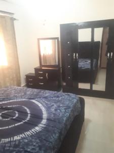 a bedroom with a bed and a dresser and a mirror at Sohna's Paradise Residence 