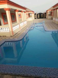 a large swimming pool in front of a building at Sohna's Paradise Residence 