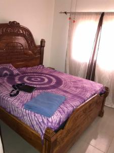 sypialnia z drewnianym łóżkiem i fioletowym kocem w obiekcie Sohna's Paradise Residence 