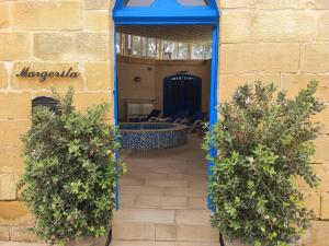 a doorway into a building with two potted plants at Margerita Farmhouse in Qrendi