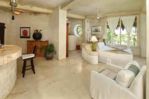 ein großes Wohnzimmer mit weißen Möbeln und einem Bett in der Unterkunft Tia Adriana in Sayulita