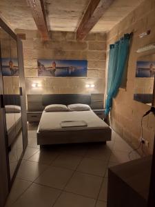 une petite chambre avec un lit et un miroir dans l'établissement Margerita Farmhouse, à Qrendi