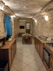 una cucina con armadi in legno e un tavolo in una stanza di Margerita Farmhouse a Qrendi