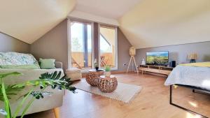 sala de estar con cama y TV en L'Evasion - Balcon - Fibre - Calme - RBNB, en Bollwiller