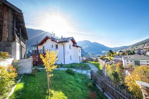 a village in the mountains with the sun in the sky at Apartments Vedl Luech da Plajes in Ortisei
