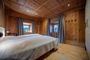 a bedroom with a bed in a log cabin at Apartments Vedl Luech da Plajes in Ortisei