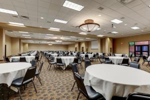 une grande chambre avec des tables et des chaises. dans l'établissement Stoney Creek Hotel Sioux City, à Sioux City