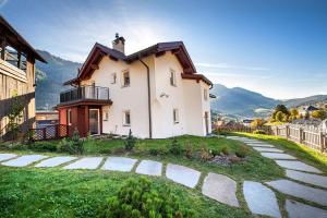 a house on a hill with a stone walkway at Apartments Vedl Luech da Plajes in Ortisei