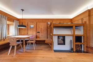 a room with a dining table and a bunk bed at Apartments Vedl Luech da Plajes in Ortisei