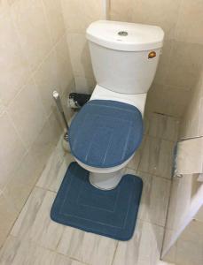 a bathroom with a toilet with a blue rug at Lovely 1-bedroom rental unit for short stays. in Tema