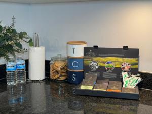 a counter top with a box of food and drinks at Luxe Lodge Woolwich Arsenal in Woolwich