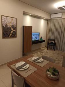 einen Esstisch mit Stühlen und einen TV in der Unterkunft THERMAS SÃO PEDRO RESORT in São Pedro