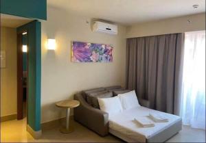 Zimmer mit einem Bett, einem Sofa und einem Fenster in der Unterkunft THERMAS SÃO PEDRO RESORT in São Pedro