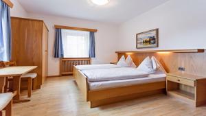 a hotel room with a bed and a table at Apartments Villa Alpina in Santa Cristina in Val Gardena