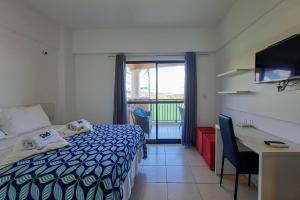 sypialnia z łóżkiem, biurkiem i oknem w obiekcie Beverly Hills 2 Suítes Apto Completo 500m Praia w mieście Aquiraz
