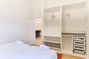 a white bedroom with two beds and a mirror at TuApartamento Boutique & Art - Corralillos del Gas in Pamplona