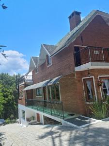 un gran edificio de ladrillo con balcón. en Recanto Ursa Maior, en Monte Verde