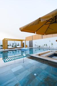 a large swimming pool with a large yellow umbrella at Nammos Experience in Amman
