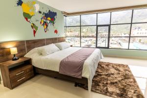 een slaapkamer met een groot bed en een groot raam bij APARTAMENTOS MONACO in Baños