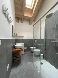 a bathroom with two toilets and a glass shower at I Ciliegi del Conte in Bormio