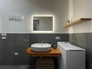 a bathroom with a sink and a toilet and a mirror at I Ciliegi del Conte in Bormio