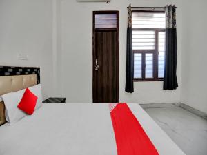 a bedroom with a bed and a window with a red pillow at OYO Flagship Hotel Royal Choice in Rohtak
