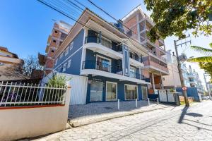 een blauw-wit gebouw in een stadsstraat bij Ideal para Casais, Loft na Praia de Bombinhas - 1 dorm in Bombinhas