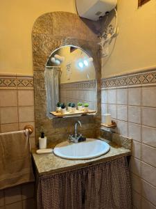 y baño con lavabo y espejo. en Finca el Lomo en Las Palmas de Gran Canaria