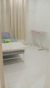 una camera ospedaliera con un letto e un tavolo di Homestay Taman Tiara Paka a Paka