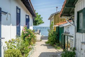 an alleyway between buildings with the ocean in the background at Chalet Cosy in Lège-Cap-Ferret