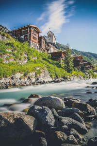 a river with rocks and a church on a hill at @tiefenmatten 19 in Blatten im Lötschental