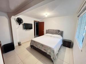 1 dormitorio con 1 cama y TV de pantalla plana en Panorama, en Villavicencio