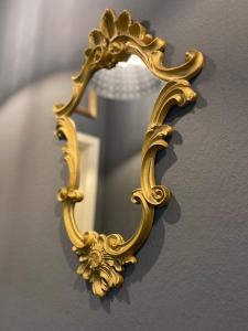 a gold mirror hanging on a wall at Blue Royal Apartment in Celle