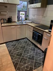 a kitchen with a black and white floor at Blue Royal Apartment in Celle