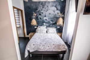 1 dormitorio con 1 cama y papel pintado con motivos florales en LE DUPE, en Brissac-Quincé