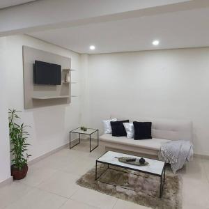 a white living room with a couch and a table at Apartamento nuevo, Asunción. in Asunción