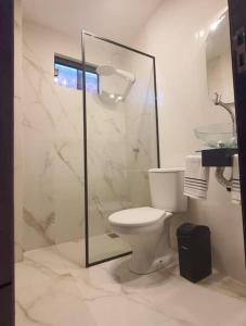 a bathroom with a toilet and a glass shower at Apartamento nuevo, Asunción. in Asunción